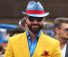 A man in blue color cow boy hat and yellow suit